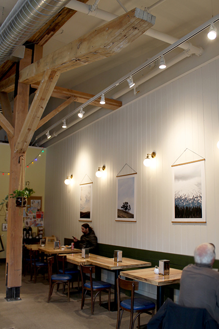 White paneling lines the walls, local art hangs behind wooden tables